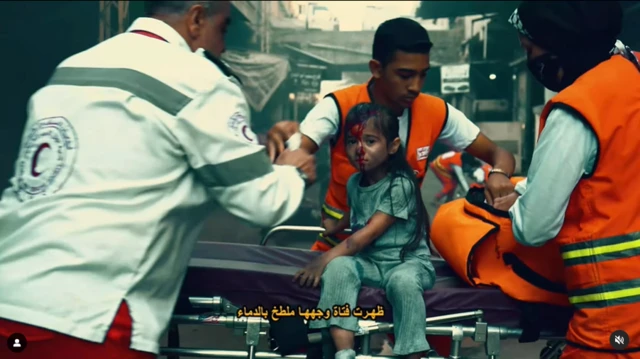 A girl sitting on a hospital bed surrounded by camera crew.