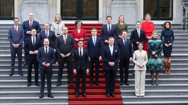 Министры, их заместители, Роб Йеттен и король Виллем-Александр позируют перед зданием в Гааге.