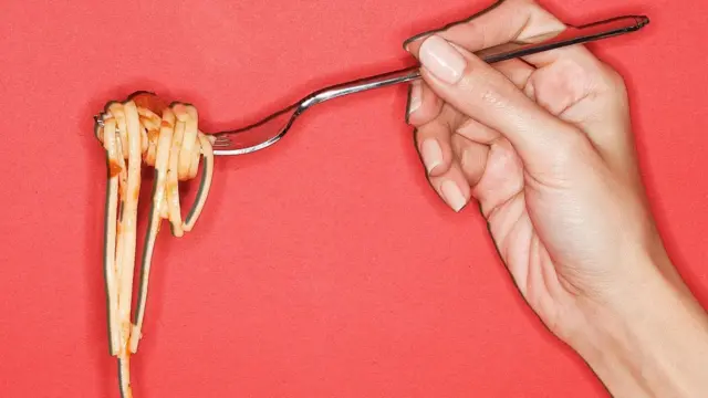 Spagetti dolamış bir çatalı tutan el.