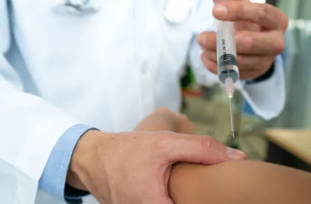 Médico injetando medicamento em paciente
