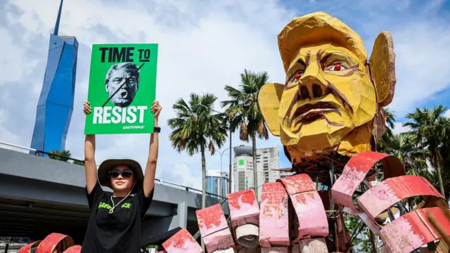 Žena drži natpis „Vreme je za otpor“ pored velike lutke sa likom američkog predsednika Donalda Trampa u Kuala Lumpuru, Malezija.