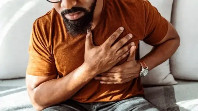 Um homem com a mão no peito