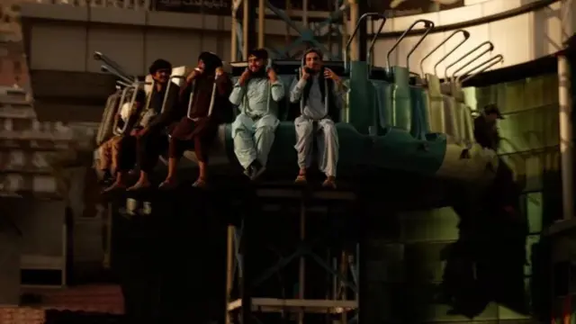 Des hommes assis un manège.