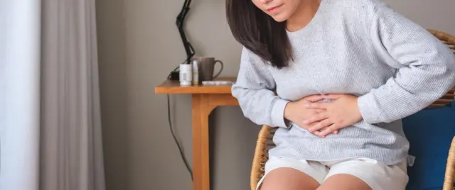 Karnını tutan bir kadın