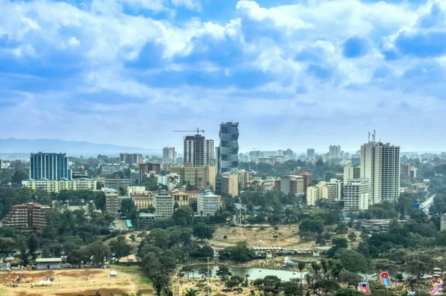 Vue aérienne de Nairobi, avec quelques gratte-ciels et un parc verdoyant agrémenté d'un lac, au Kenya, en Afrique.