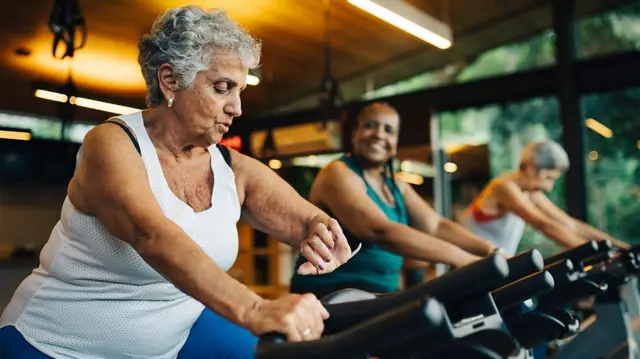 Tres mujeres ejercitándose en bicicletas estáticas