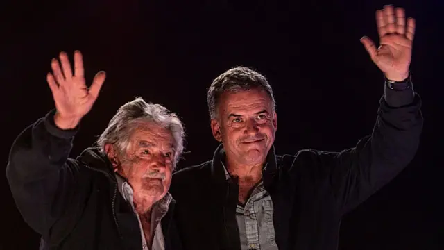 Uwahoze ari Perezida wa Uruguay José Mujica ari kumwe n'umukandida perezida Yamandú Orsi w'ishyaka Frente Amplio, basuhuza ababashyigikiye, aha ni muri mitingi yo gusoza ibikorwa byo kwiyamamaza, muri Mata (4) mu mwaka wa 2024, i Montevideo, muri Uruguay. (Ifoto yafotowe na Ernesto Ryan wa Getty Images).