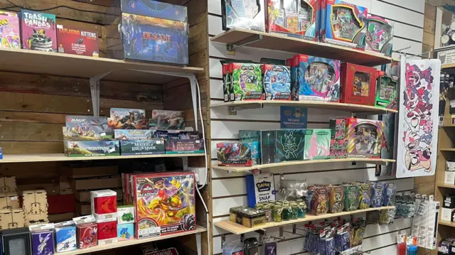 Estantes llenos de diferentes tipos de cartas coleccionables dentro de la tienda Dice Jail