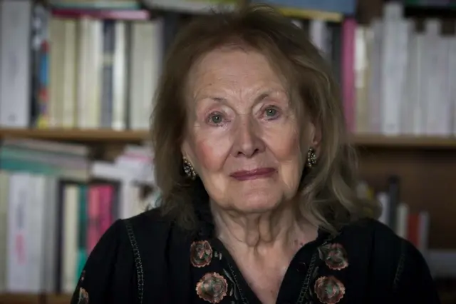 Анні Ерно на тлі полиць з книгами, сучасне фото