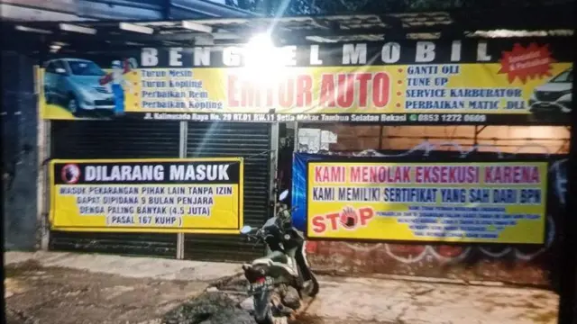 Spanduk menolak eksekusi lahan di depan bengkel Yealdi.