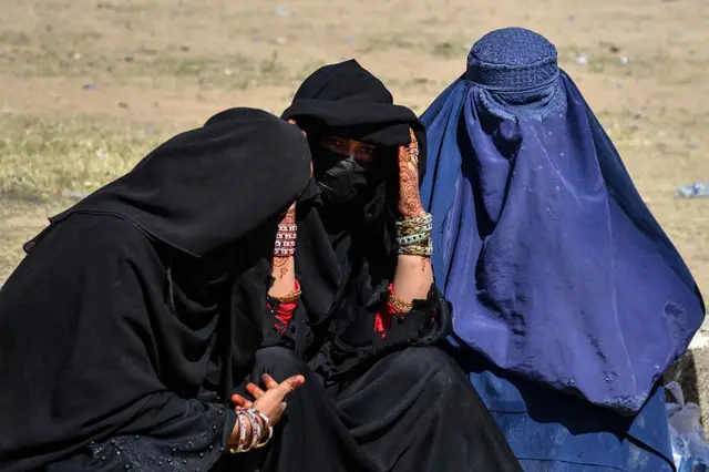 13 Nisan'da Pakistan'dan ülkelerine dönen ve Kandahar'daki bir kayıt merkezinde görüntülenen üç Afgan kadın. Kadınların üzerinde burka var. 