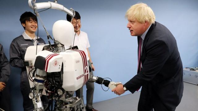 約翰遜在訪問日本時和機器人互動