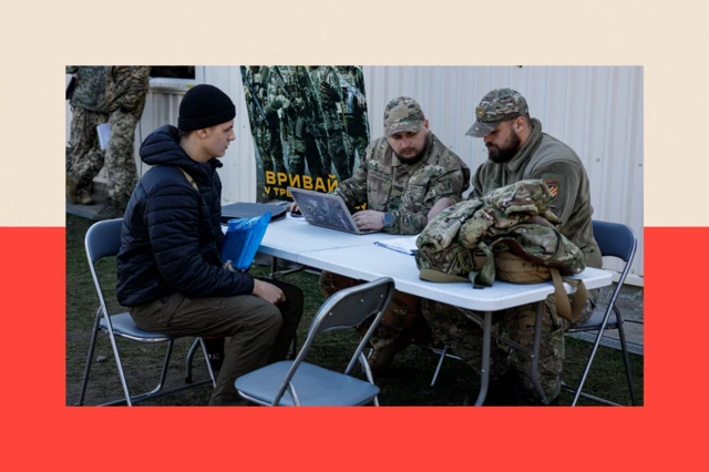 Servicemen talk with a young man at the conscription point 