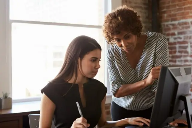 Des femmes consultant un ordinateur.