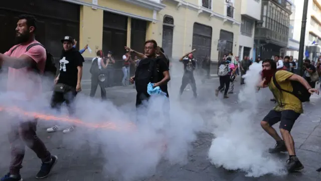 Manifestantes protestando contra el indulto en medio de gases lacrimógenos.