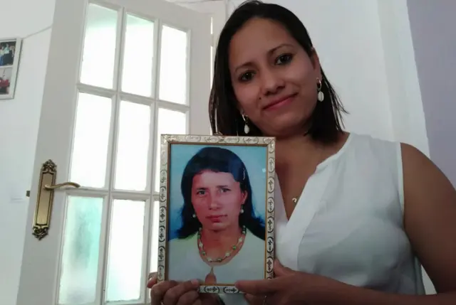 Isamar con un retrato de su madre