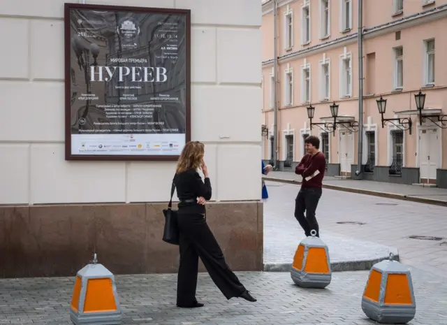 Mujer ante el cartel que anuncia el estreno de "Nureyev" en Moscú.