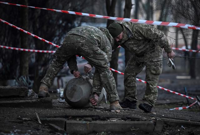 أعضاء فريق القنابل يحملون أجزاء من صاروخ بعد هجوم صاروخي روسي على كييف ( أرشيفية)