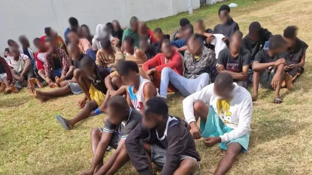 Suspects sit on the floor