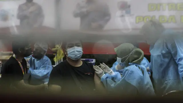 Petugas kesehatan memberikan vaksin booster Covid-19 kepada warga di Jakarta.