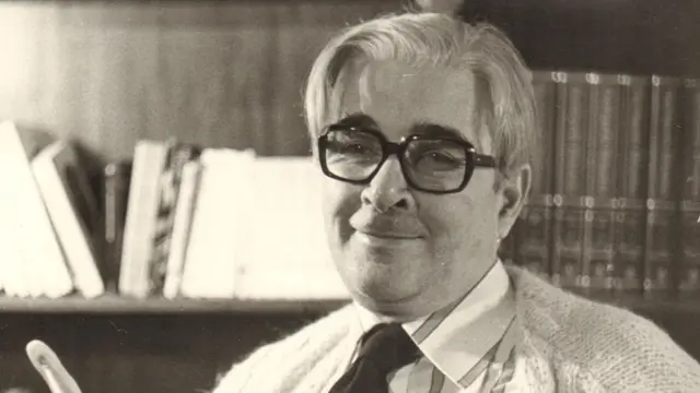 Bogdan Bogdanović u beloj košulji sa kravatom gleda u kameru, sa naočalama na licu, crno-bela fotografija, portret