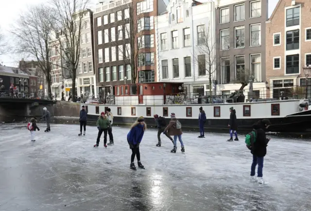 People ice skate during a cold snap across the country at the Prinsengracht in Amsterdam, Netherlands February 14, 2021.