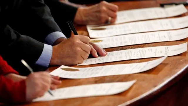 Electores del Colegio Electoral firmando actas