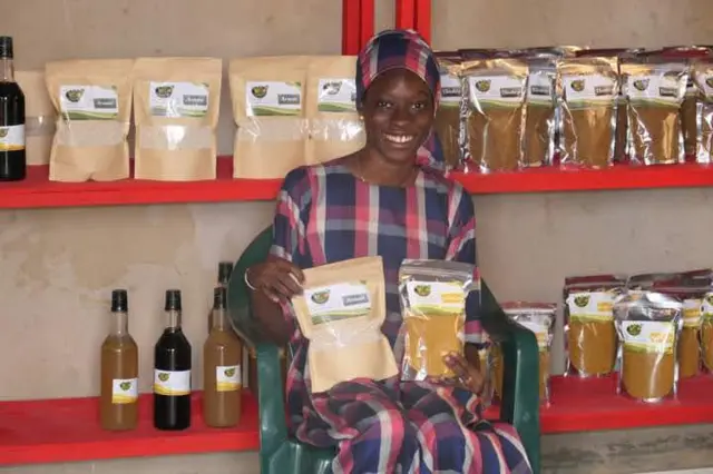 Mariama toute souriante dans sa boutique de produits locaux