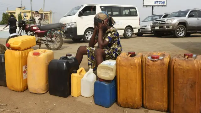 Woman siddon with jerry can for petrol station