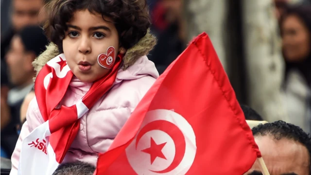 طفلة تتلفع بـ علم تونس