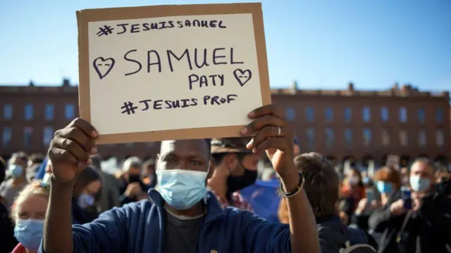 Un hombre en una manifestación en Francia con un cartel que dice "Yo soy Samuel", "Yo soy profesor".