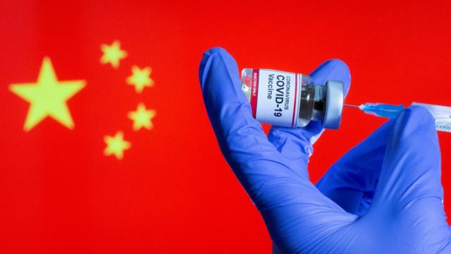 設計圖片：一位女護士在中國國旗前預備新冠疫苗針劑