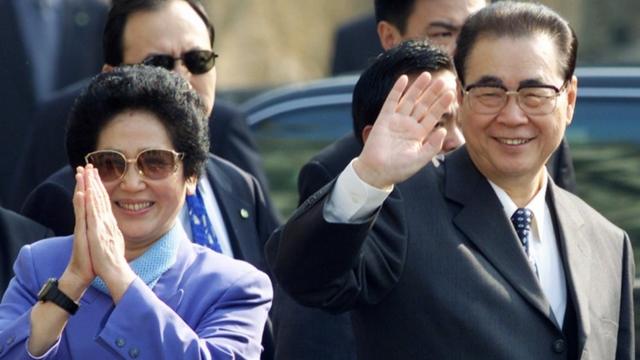 Li Peng and his wife Zhu Lin wave to crowds