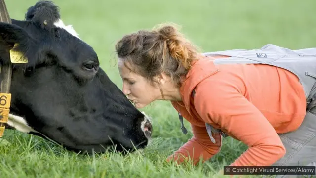 Mulher beijando vaca