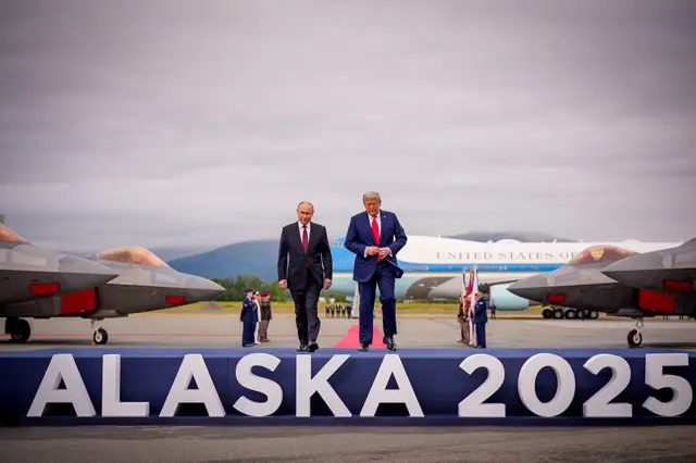 Путин и Трамп на фоне большой надписи Alaska 2025 на встрече в Анкоридже
