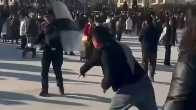 畫面顯示抗議者向手持盾牌的警察投擲物品。
