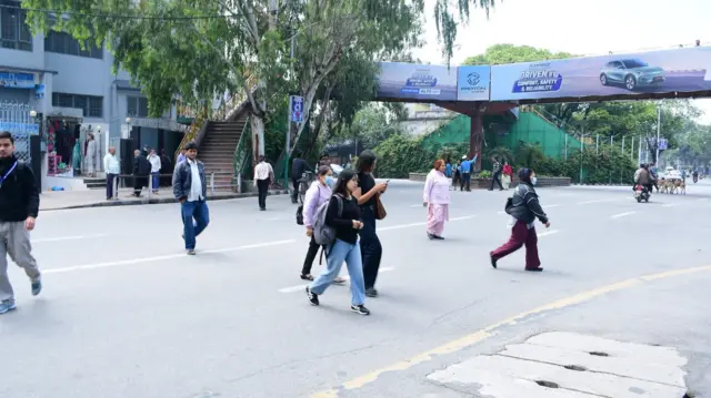 आकाशे पुलनजिकै सडकबाटै बाटो काट्ने पैदलयात्रीहरू