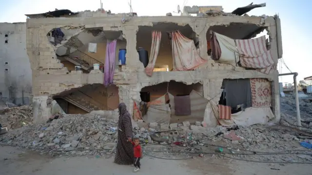 Una mujer y un niño caminan por la ciudad de Jan Yunis, en el sur de la Franja de Gaza