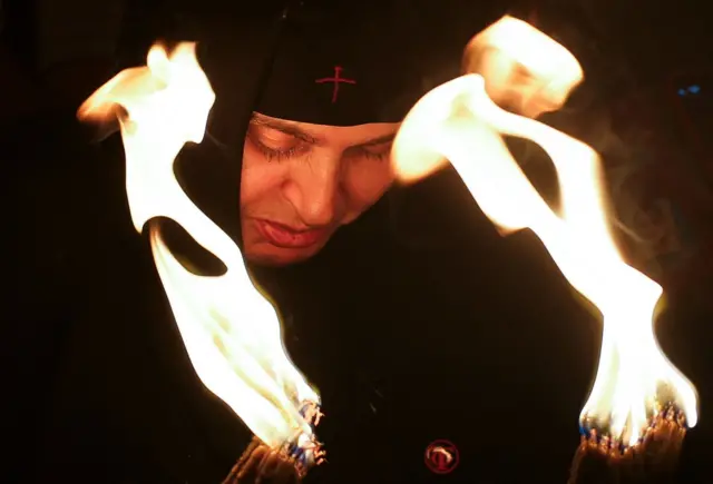 Monahinja drži sveće u Jerusalimu