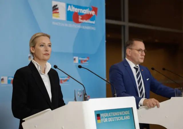 The co-leaders of the far-right Alternative for Germany (AfD) party Alice Weidel and Tino Chrupalla standing on a stage