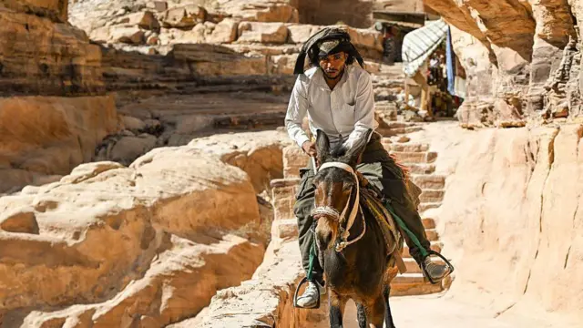 یو کس پر خره ناست دی او پر سر یې دسمال اچولی دی