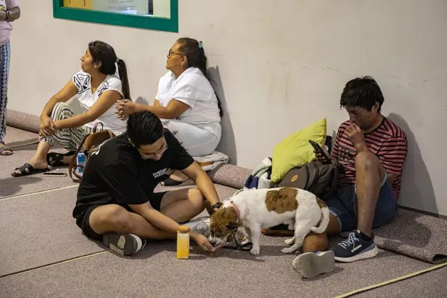 Evlerinden tahliye edilen İspanyollar spor salonlarına yerleştirildi. Burada bir köpeğe mama veren adam görülüyor
