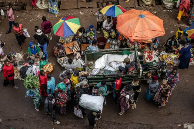 Les gens se rassemblent autour des étals de marché à Bukavu.