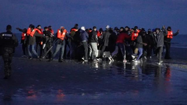 Hai nhóm người nhập cư chen nhau lên thuyền sáng ngày 23/4 tại bờ biền Manche