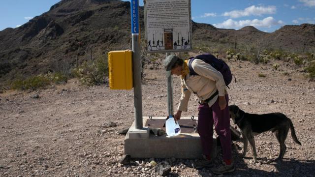Activista de "No More Deaths" dejando un galón de agua en el desierto.