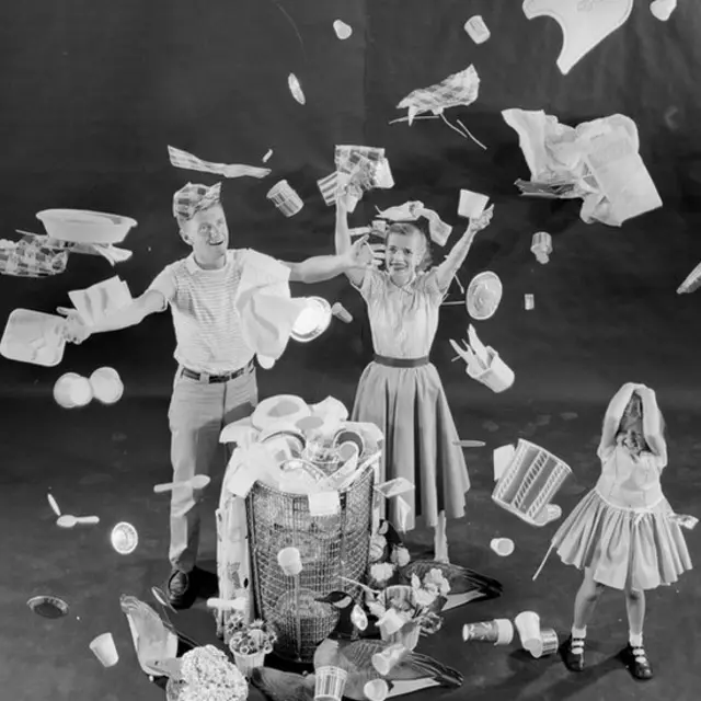 Familia feliz llenando la caneca de basura con productos desechables.