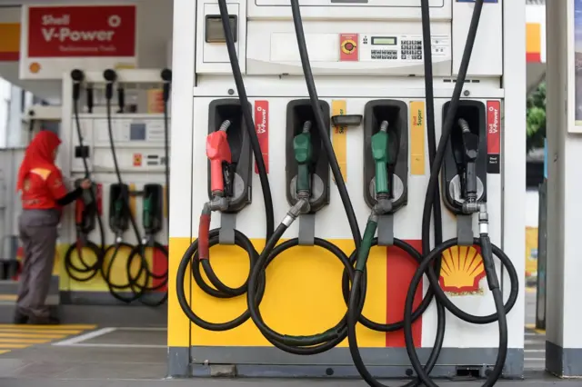 Petugas SPBU sedang bersih-bersih.