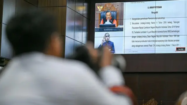 Layar menampilkan Ketua Mahkamah Konstitusi (MK) Suhartoyo saat memimpin sidang gugatan undang-undang tentang Tabungan Perumahan Rakyat (Tapera) di Gedung Mahkamah Konstitusi, Jakarta, Senin (29/9/2025).