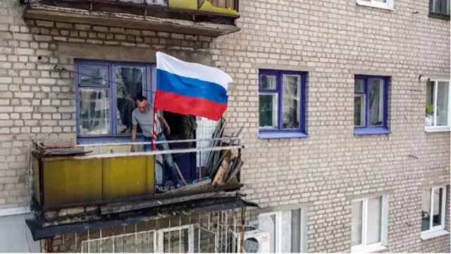 L'image montre le drapeau russe flottant sur un balcon