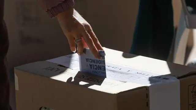 Uma pessoa deposita um voto na urna na Colômbia.